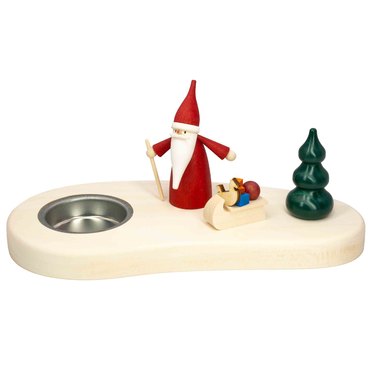 Ein moderner Teelichthalter aus Holz zeigt einen Weihnachtswichtel mit rotem Gewand und Stock daneben ein Schlitten mit Geschenken und eine grüne Tanne