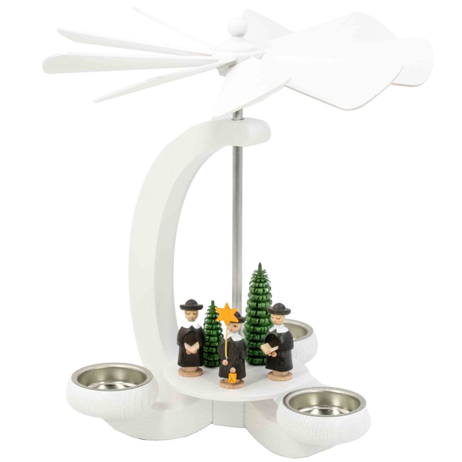 Eine weiße Teelichtpyramide in Bogenform zeigt drei Kurrendesänger in schwarzer Kleidung neben grünen Tannenbäumen