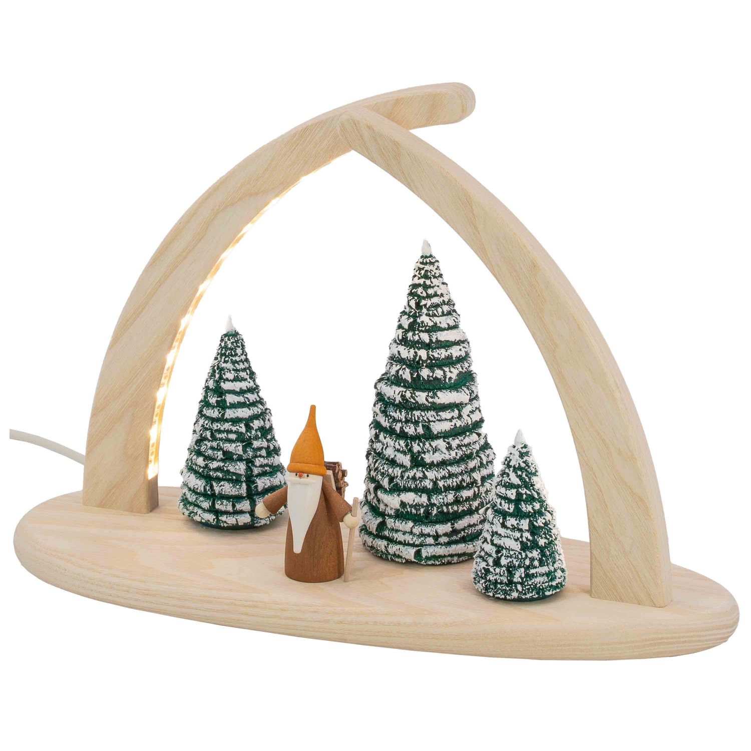 Ein dreieckiger Lichterbogen zeigt einen Waldwichtel mit weißem Bart hellbrauner Kleidung und Holzstücken auf dem Rücken umgeben von verschneiten Tannen