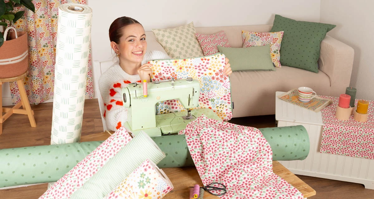 Frau näht aus gemustertem Baumwollstoff ein Kissen – kreative DIY-Idee mit Stoffen von SCHÖNER LEBEN
