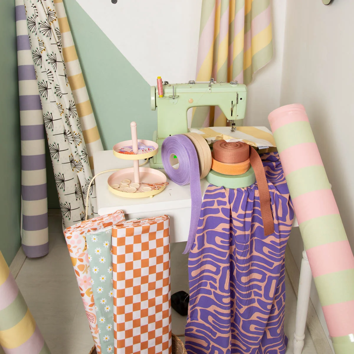 Bunte Stoffrollen und Dekostoffe als Meterware mit Retro-Mustern in einem kreativen Nähzimmer – ideal für DIY und individuelle Wohnideen.