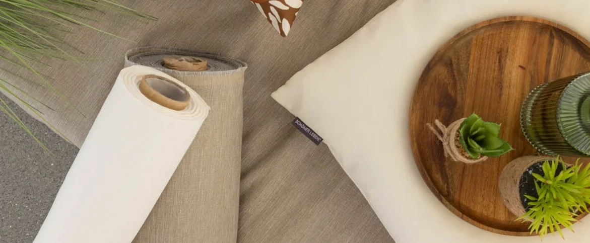 ein weiße und eine beige Rolle Meterware Polsterstoff mit Fleckschutz