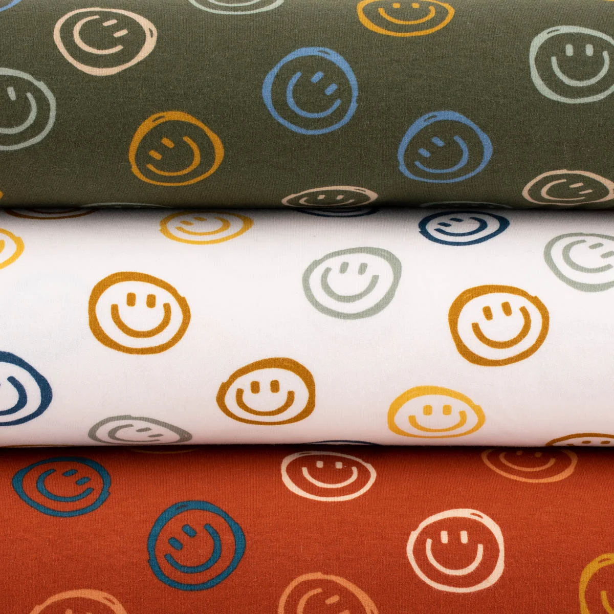 Gemusterter Sweatstoff mit Smileys in verschiedenen Farben Gemusterter Sweatstoff mit Smileys in verschiedenen Farben