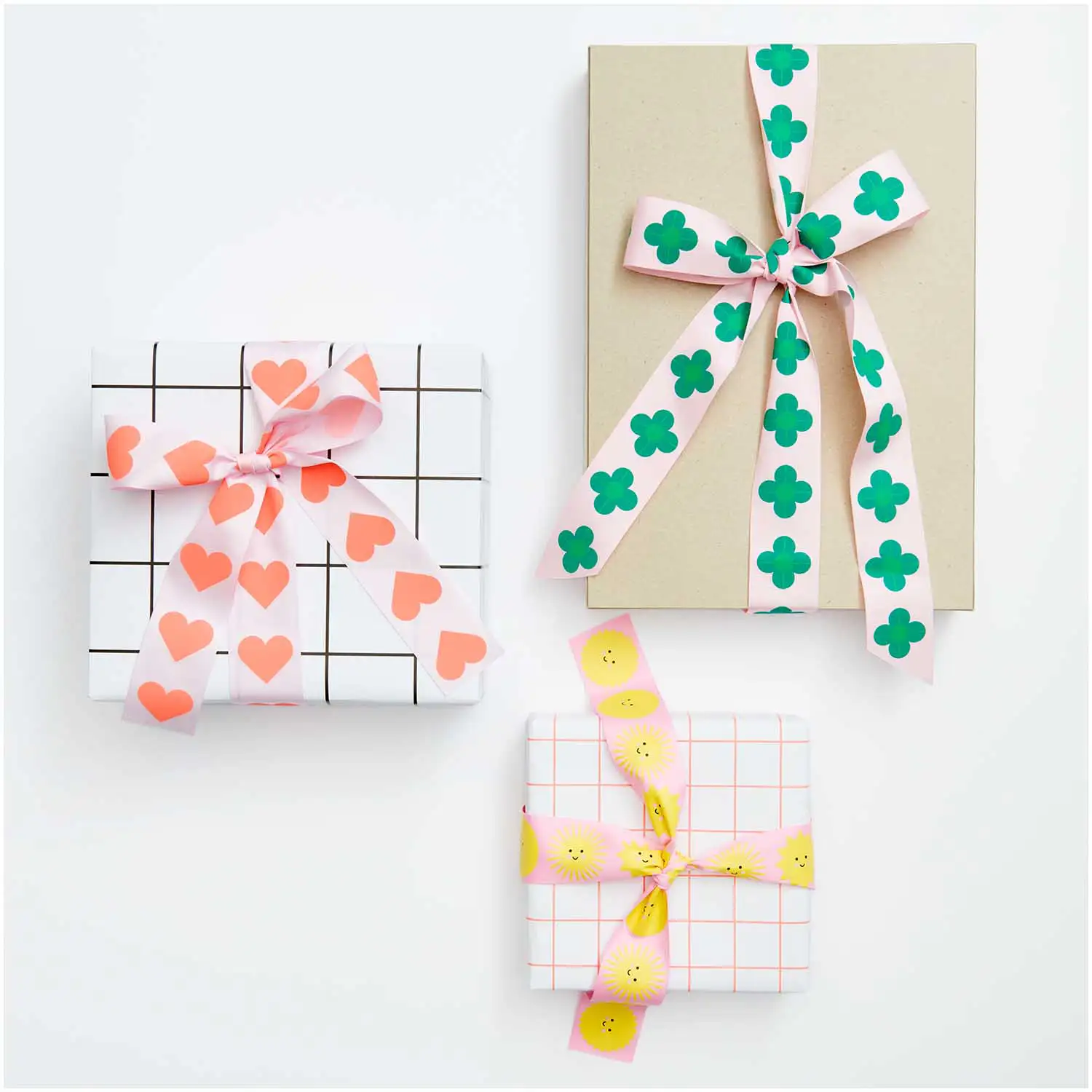 Drei eingepackte Geschenke mit gemustertem Geschenkband