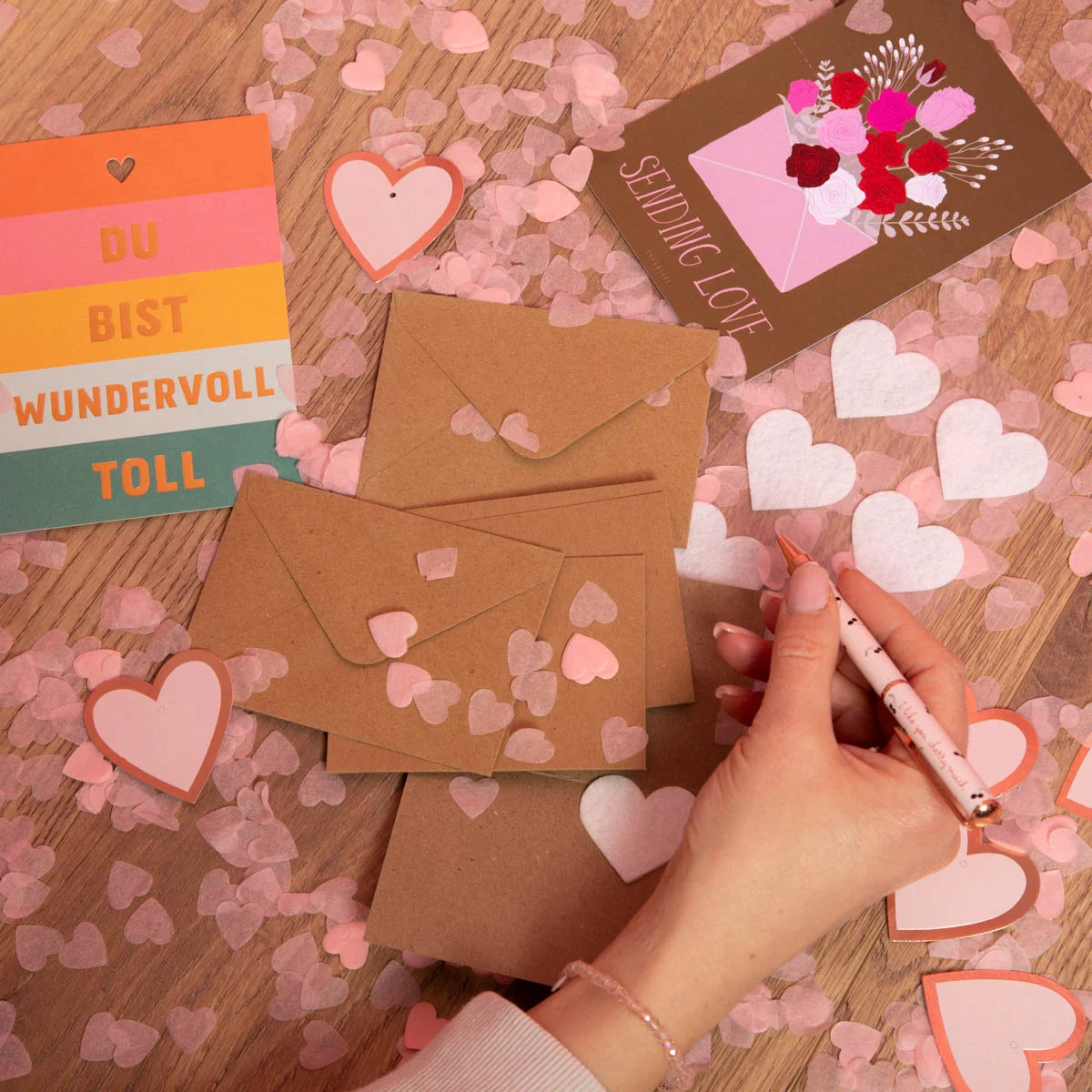 Handgeschriebene Valentinstagskarte mit Herz-Konfetti und braunen Umschlägen – kreative DIY-Ideen für liebevolle Botschaften und Geschenke.