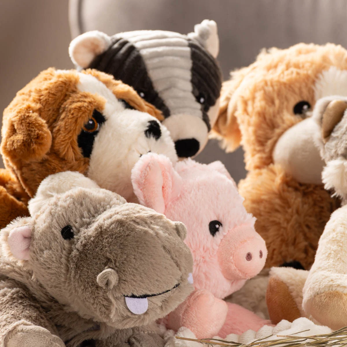 Kuschelige Wärmestofftiere in verschiedenen Tierformen, darunter Hund, Nilpferd, Schwein und Dachs, eng aneinandergeschmiegt.