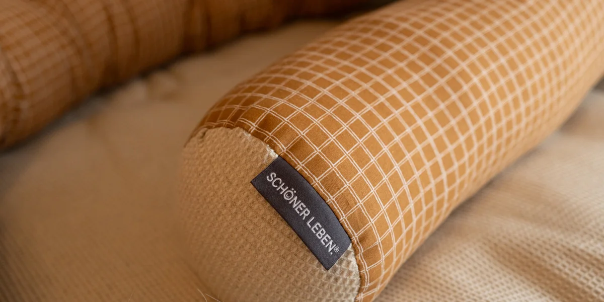 Bettschlange mit SCHÖNER LEBEN. Label aus karierten Baumwollstoff in Orange