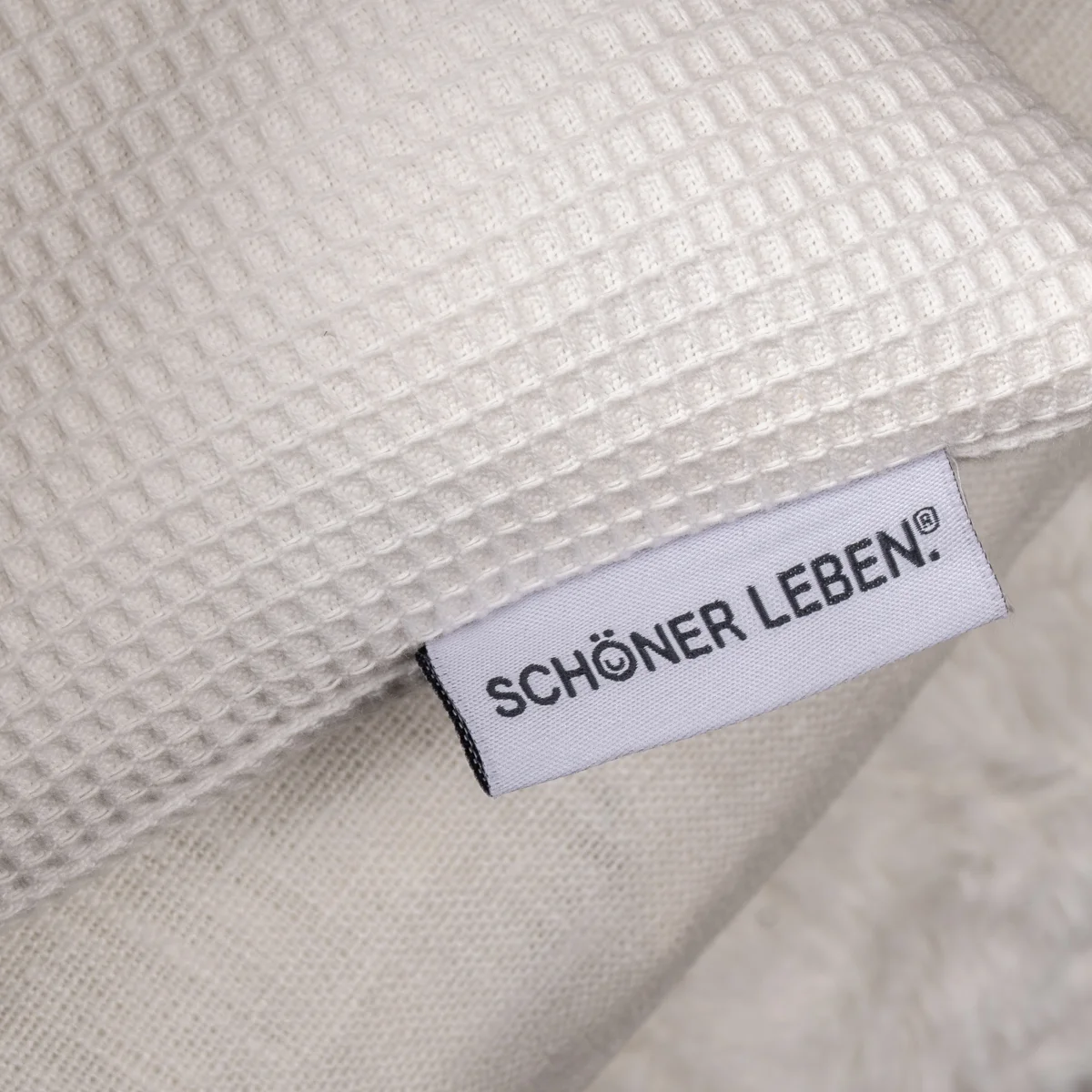 Schöner Leben Label an weißem Kissen