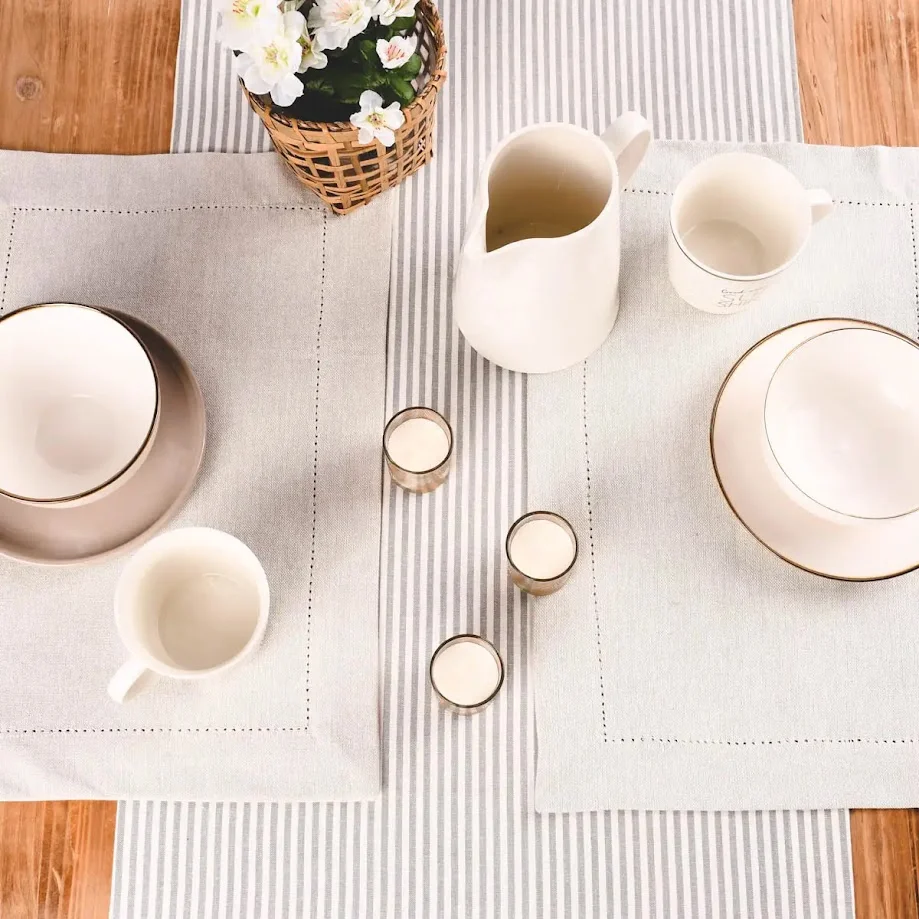 Gedeckter Tisch mit Milchkanne und Geschirr aus Steingut