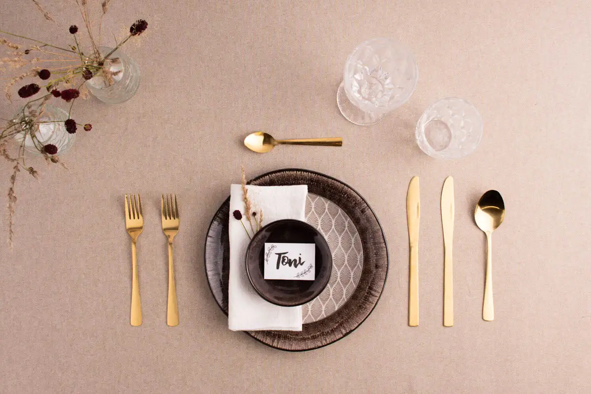 Eingedeckter Tisch für eine Person mit Tellern, Besteck und Gläsern