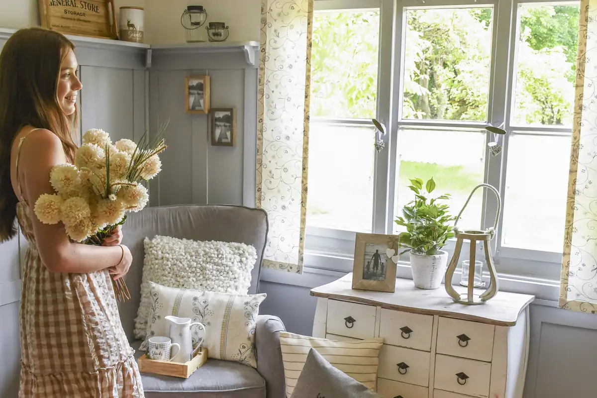 Kommode im Landhausstil dekoriert mit Bilderrahmen, Laterne und Pflanze