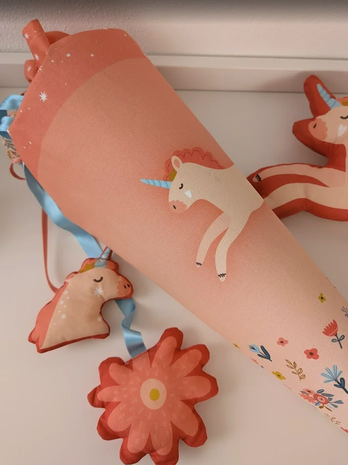 Rosa Schultüte mit niedlichem Einhornmotiv, verziert mit Blumen und passenden Anhängern – ideales Geschenk zur Einschulung für Mädchen
