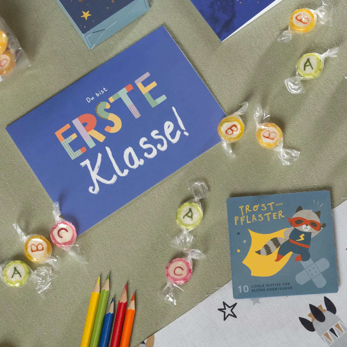Blaues Einschulungsset mit Postkarte „Du bist ERSTE Klasse!“, bunten ABC-Bonbons, Buntstiften und Trostpflaster mit Superhelden-Motiv – liebevolle Kleinigkeiten für die Schultüte