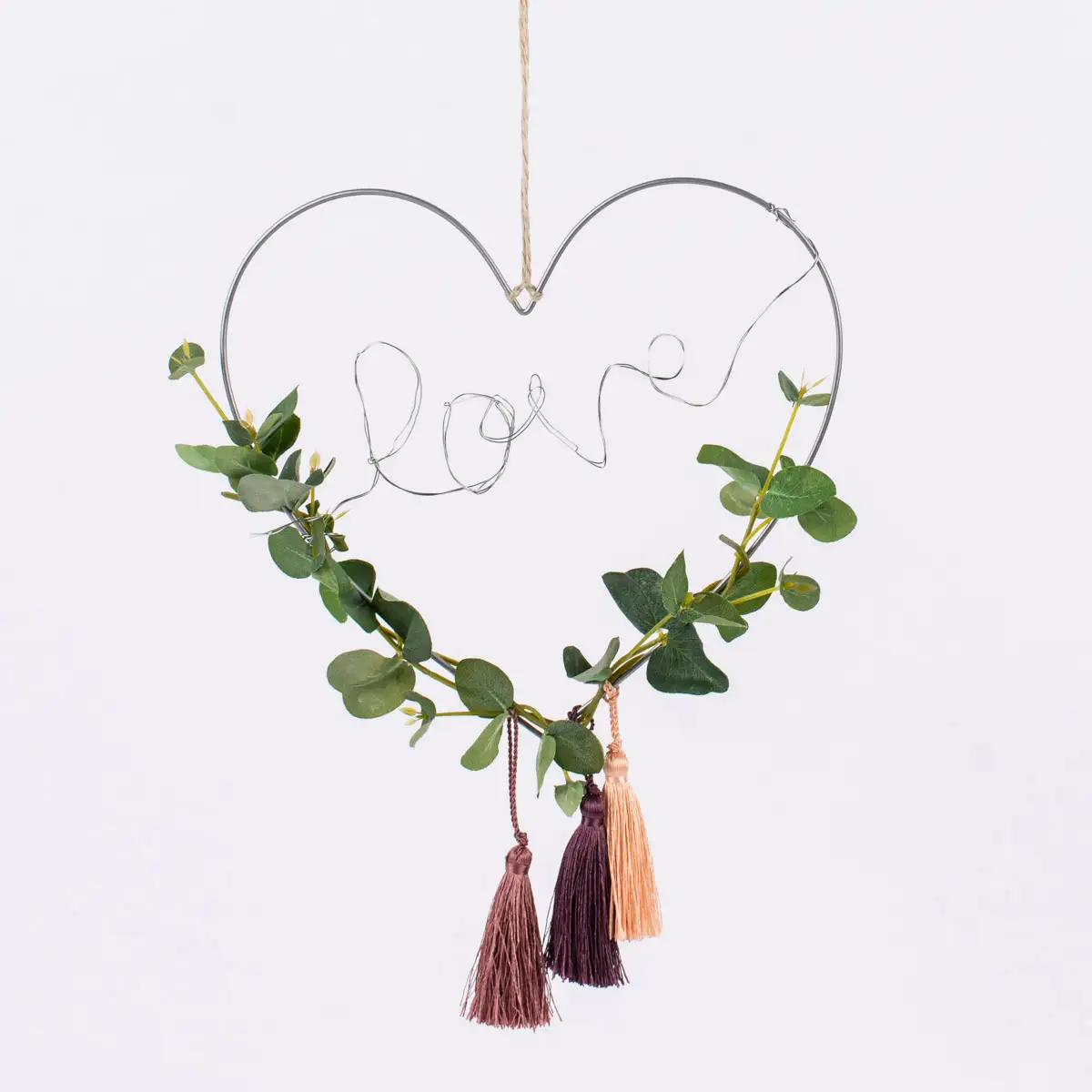 Herzförmiger Dekoring dekoriert mit Kunstpflanzen und einem Schriftzug "Love" aus Draht