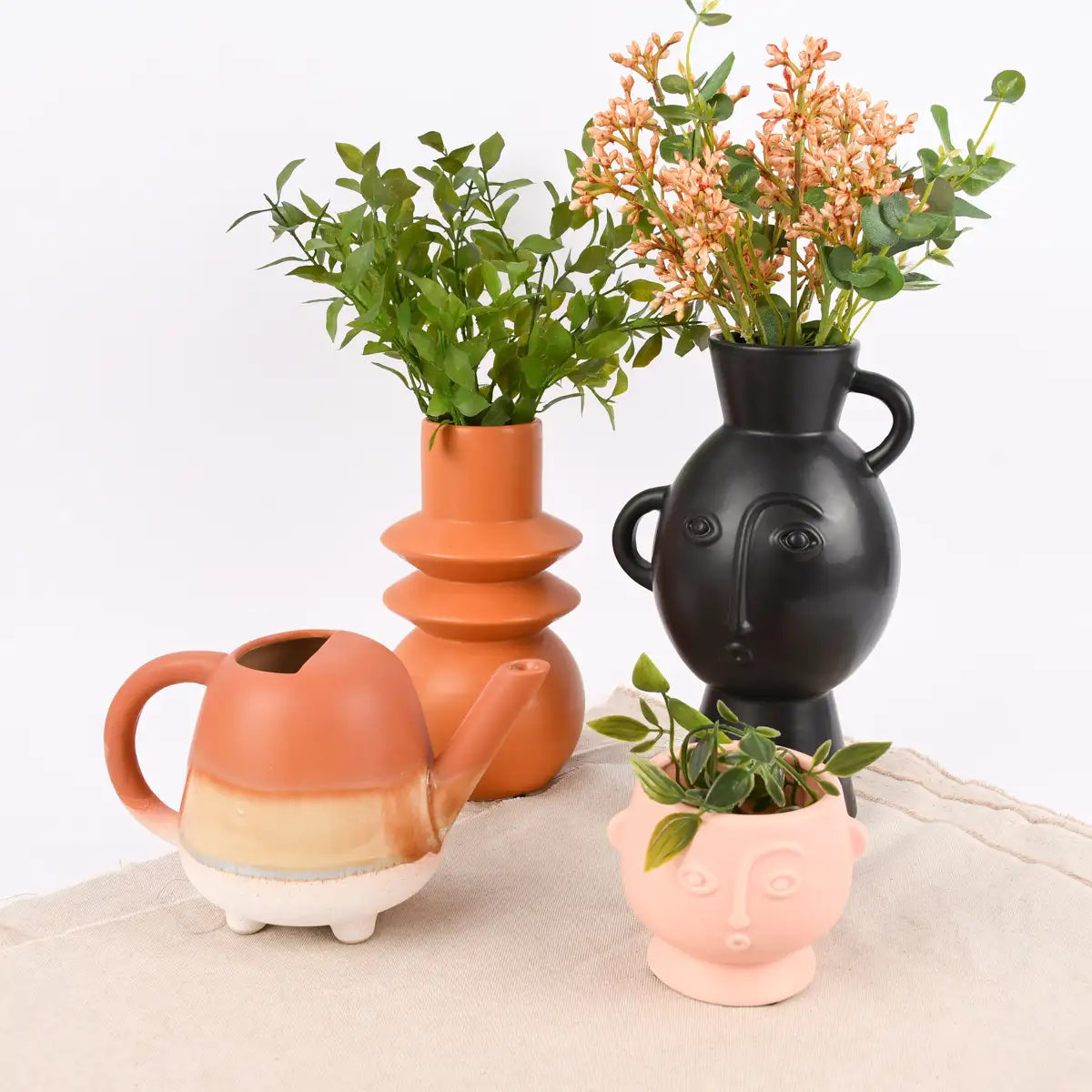 Unterschiedliche Kunstpflanzen dekoriert in Vasen und Blumentöpfen als Deko