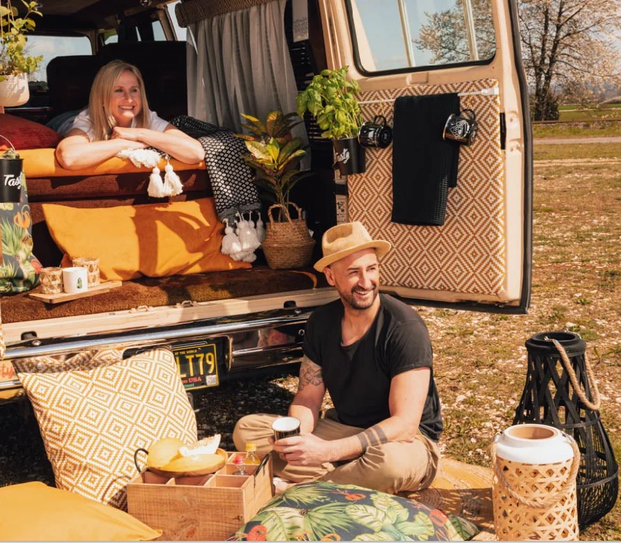 Dekoriertes Picknick vor Camper mit Laternen Dekoriertes Picknick vor Camper mit Laternen