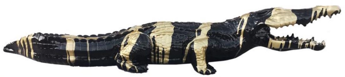 You see a very luxurious crocodile sculpture in the colors gold and black.