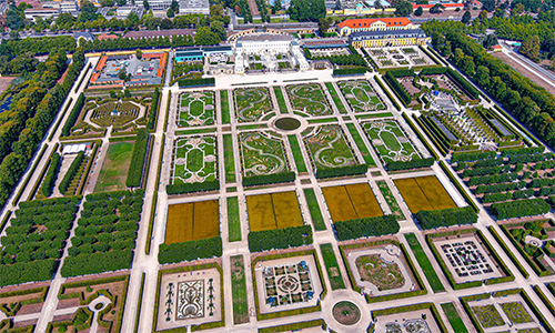 Luftbildaufnahme der Herrenhäuser Gärten in Hannover, die den Barockstil hervorheben und eine symmetrische Anordnung widerspiegeln.