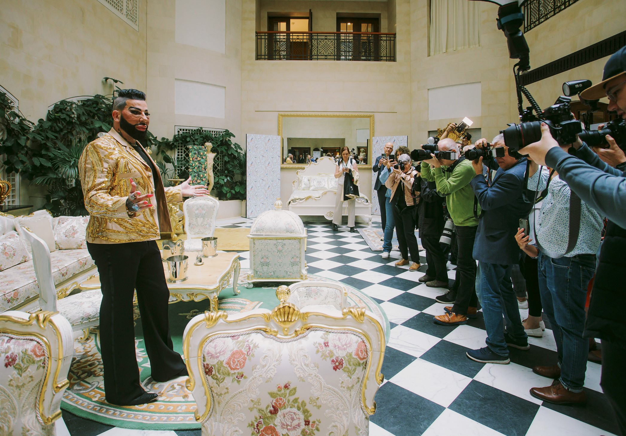 Mr. Glööckler gives an interview to the assembled press at the Adlon Hotel in Berlin, around him you can see the new furniture from the Pompöös Provance collection by Casa Padrino