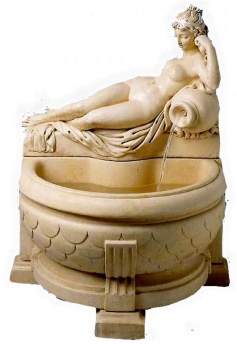 Beige wall fountain with a reclining woman leaning on a vase from which water flows into the fountain.