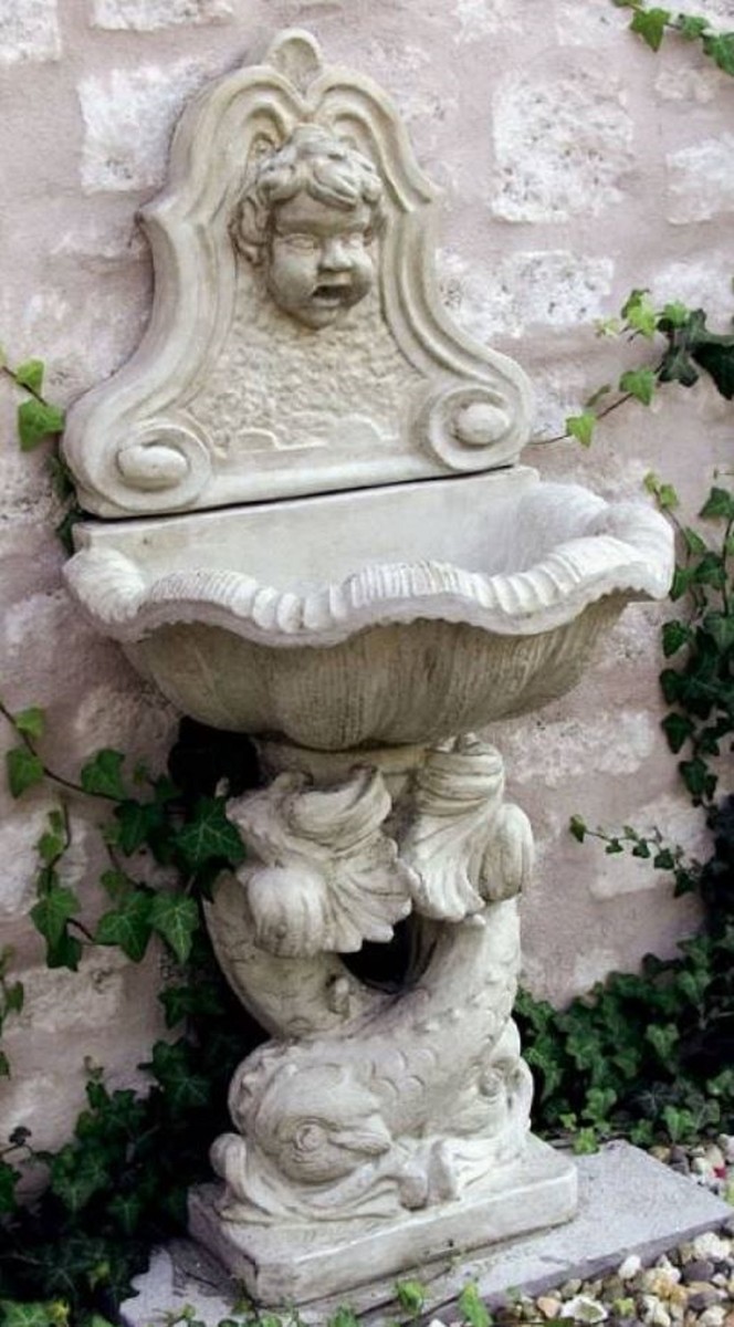 Vous voyez une fontaine murale de l'époque baroque avec une tête comme sortie d'eau.