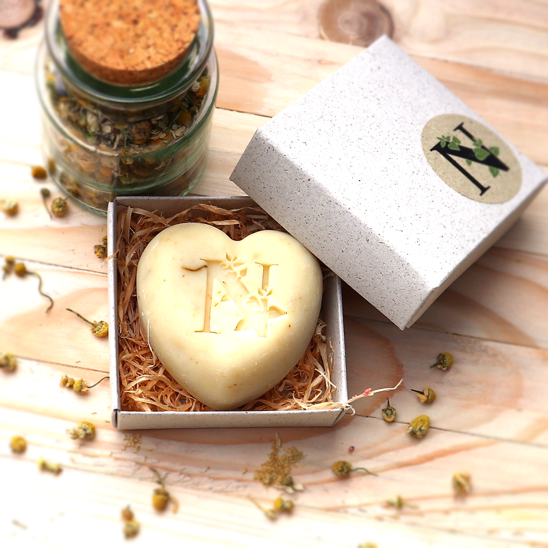 Kamille Seife 90 gram Herzform in Geschenkbox neben Kamillenblüten im Glas
