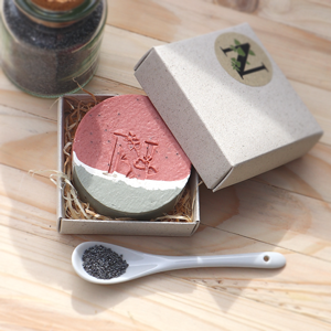 Melone Mohn Seife 90 gram rund in Geschenkbox neben Mohnsamen im Löffel und Glas